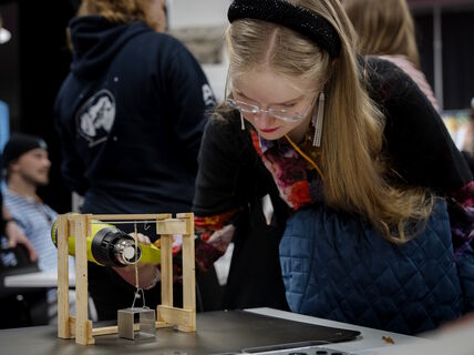 Event participant heating up a string made of heat-active material with a heatgun.