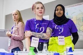 Smiling staff members from Tampereen yliopisto waiting for participants.